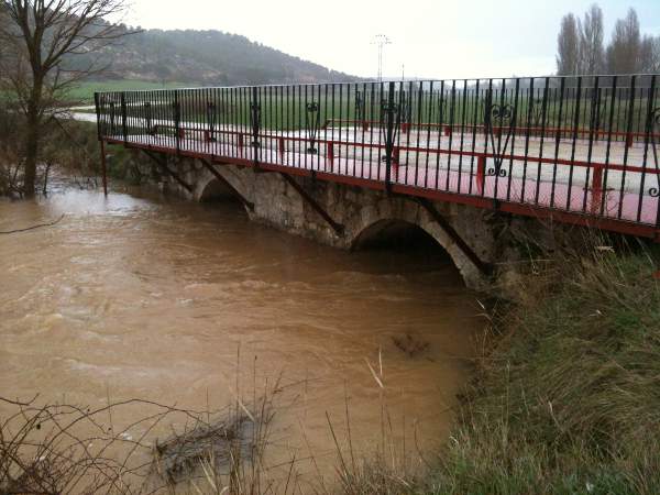 El río Esgueva crecido de forma desmesurada a su paso por el puente romano de Villatuelda en Marzo de 2013